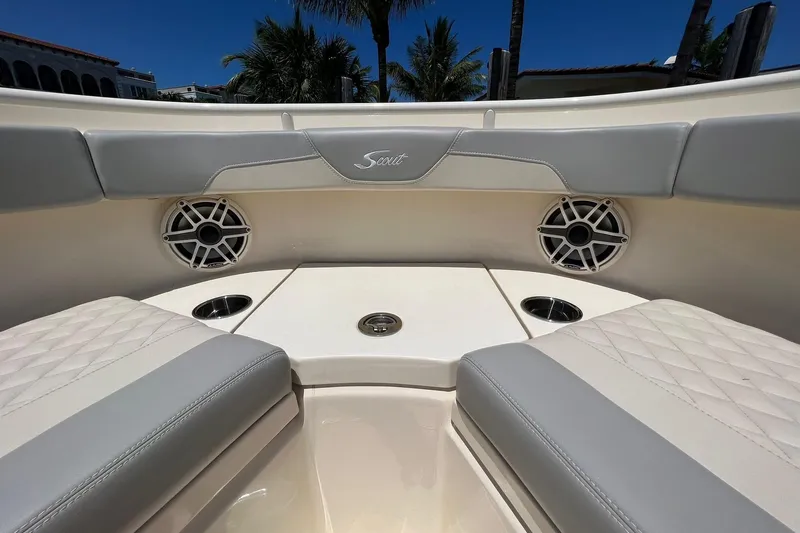 Slide: The Image of 2024 Scout 355 LXF boat interior with cushioned seating and speakers. - 16
