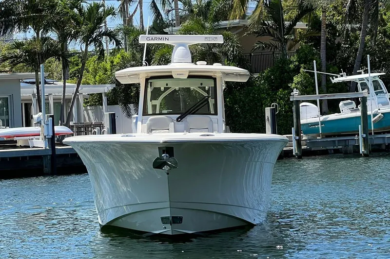 Slide: The Image of 2024 Scout 355 LXF boat docked in a marina, front view. - 2