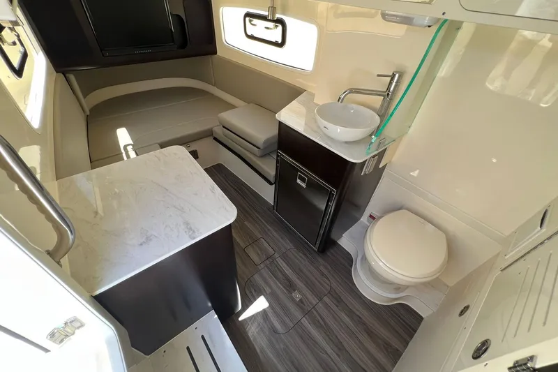 Slide: The Image of 2024 Scout 355 LXF boat interior with modern amenities, including a bed, sink, and toilet. - 20