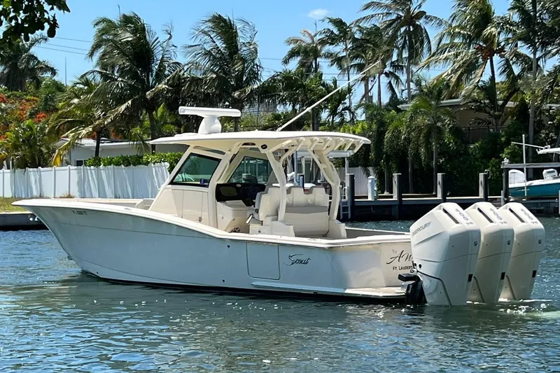 Slide: The Image of 2024 Scout 355 LXF boat with triple outboard engines on a sunny day. - 4