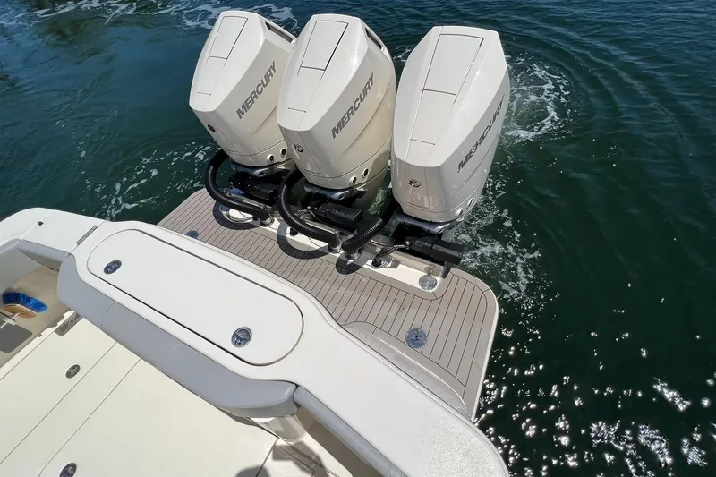 Slide: The Image of 2024 Scout 355 LXF boat with triple Mercury outboard engines on water. - 6