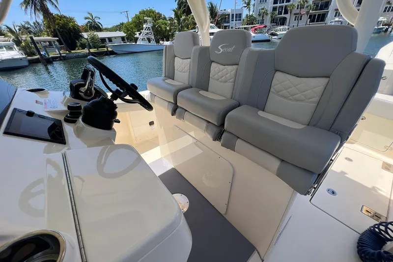 Slide: The Image of 2024 Scout 355 LXF boat interior with luxurious seating and steering console. - 9
