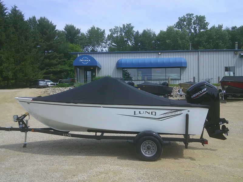 Slide: The Image of 2024 Lund 1650 Rebel XL Sport boat with cover on trailer, outside dealership. - 18