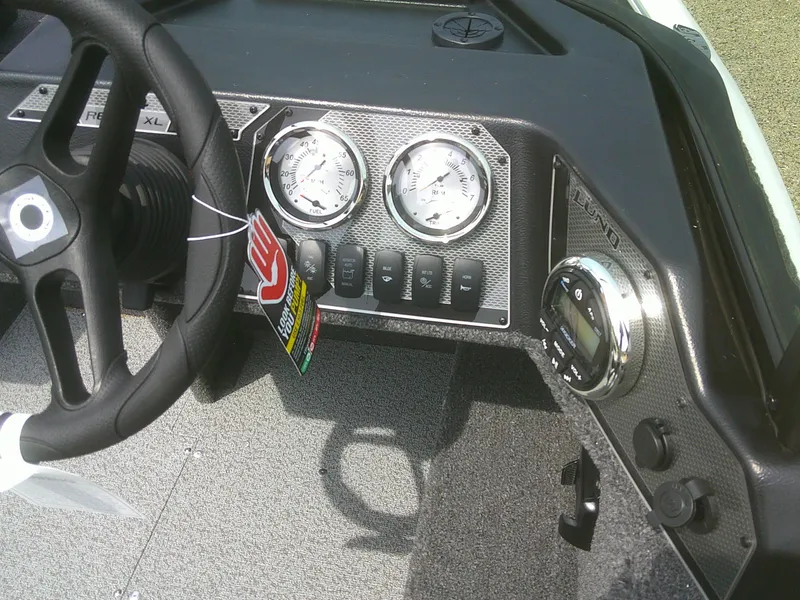 Slide: The Image of 2024 Lund 1650 Rebel XL Sport dashboard with steering wheel and gauges. - 8
