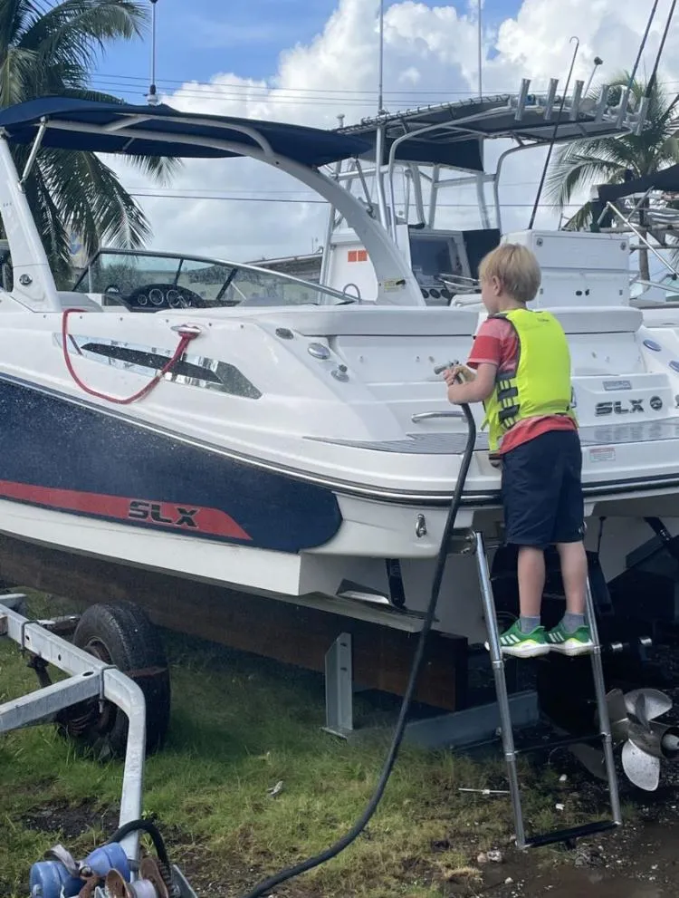 Slide: The Image of Child cleaning a 2015 Sea Ray 250 SLX boat on a trailer. - 11