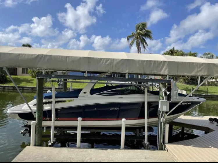 Slide: The Image of 2015 Sea Ray 250 SLX boat docked under a canopy on a sunny day. - 6