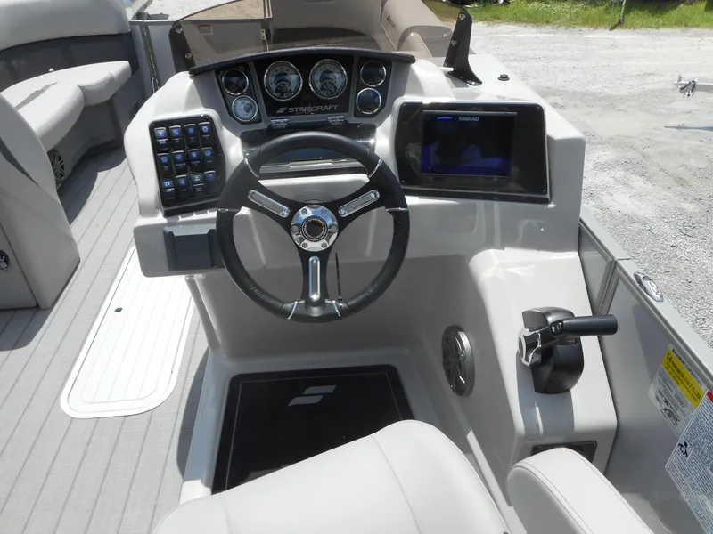 Slide: The Image of 2024 Starcraft CX 25 DL BAR boat dashboard with steering wheel and control panel. - 6