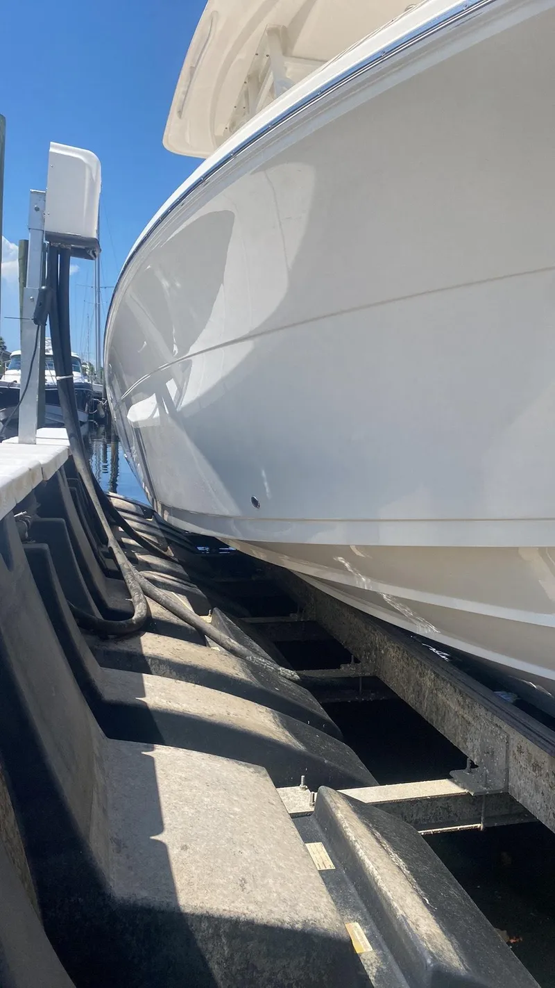 Slide: The Image of 2023 Cobia 237 Center Console boat on a trailer at a marina. - 10