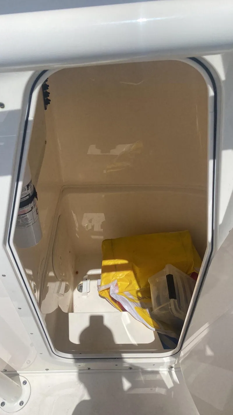 Slide: The Image of 2023 Cobia 237 Center Console storage compartment with safety gear. - 6