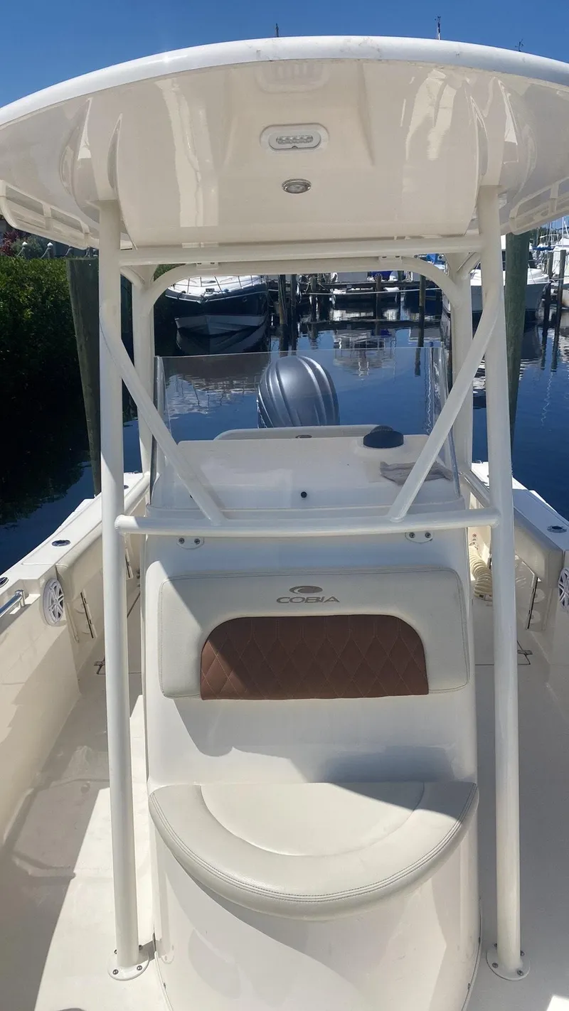 Slide: The Image of 2023 Cobia 237 Center Console boat docked at marina. - 7