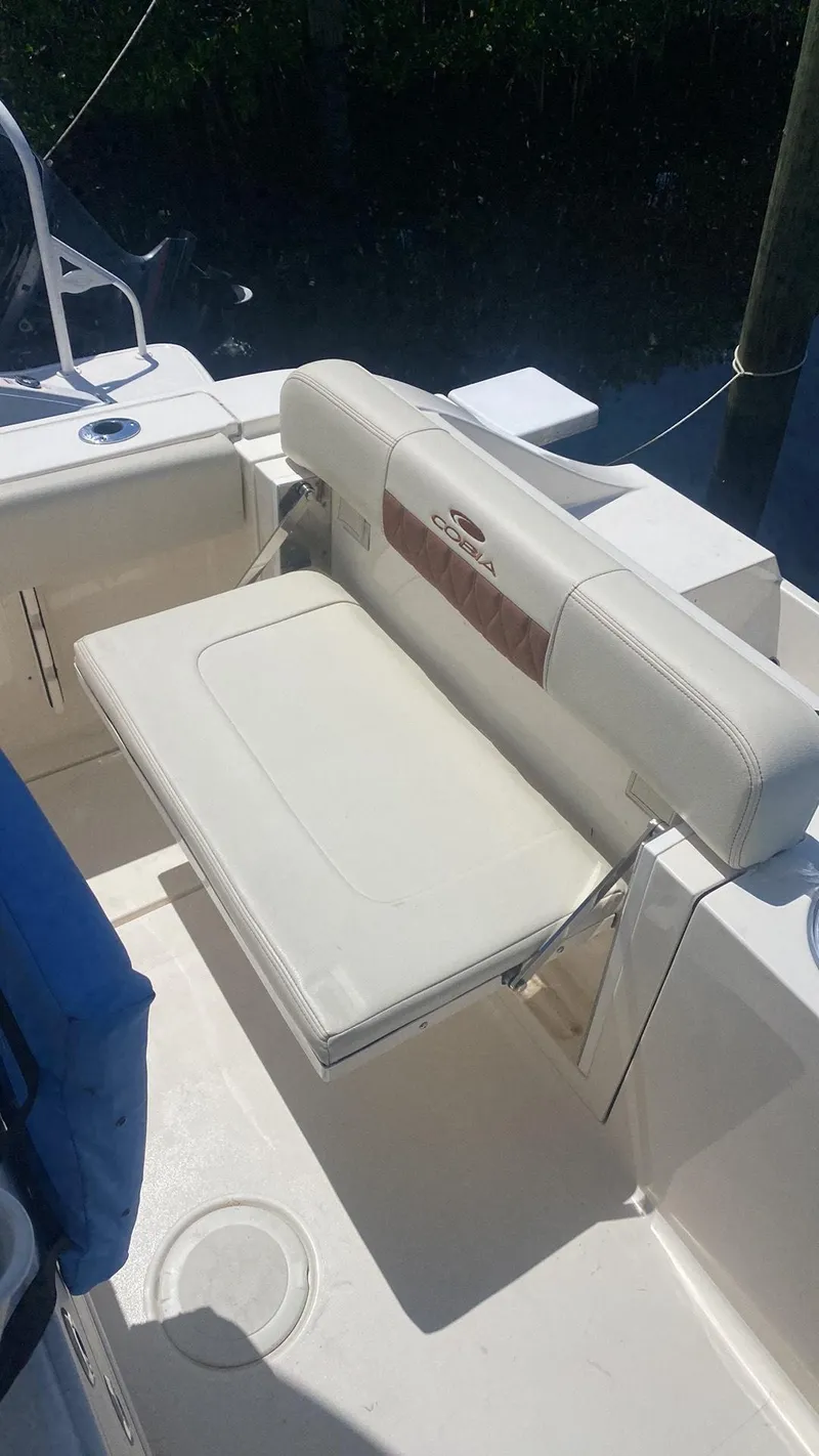 Slide: The Image of 2023 Cobia 237 Center Console boat with white cushioned seating. - 9