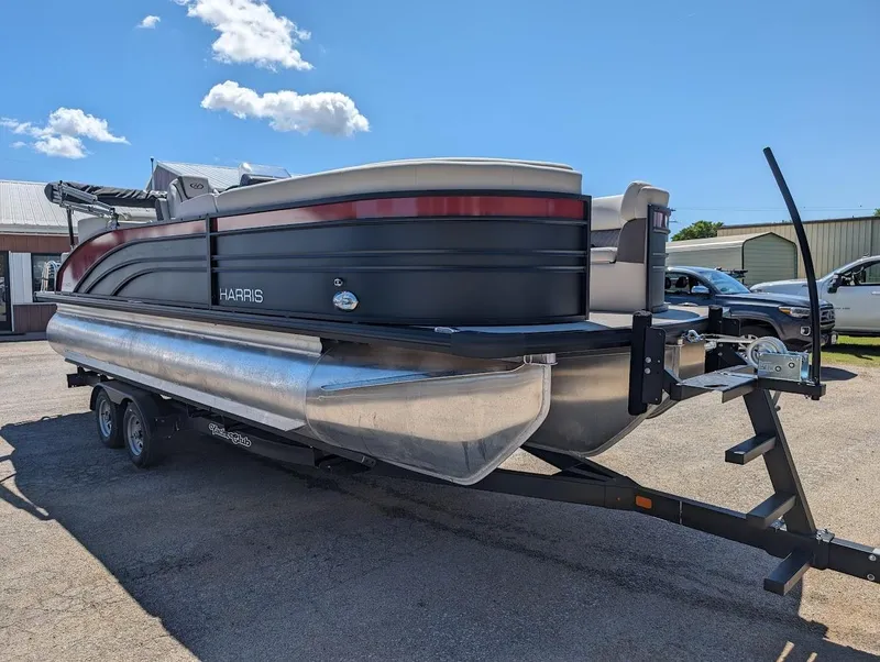 Slide: The Image of 2024 Harris FloteBote Sunliner 230 CWDH pontoon boat on a trailer under a clear sky. - 5