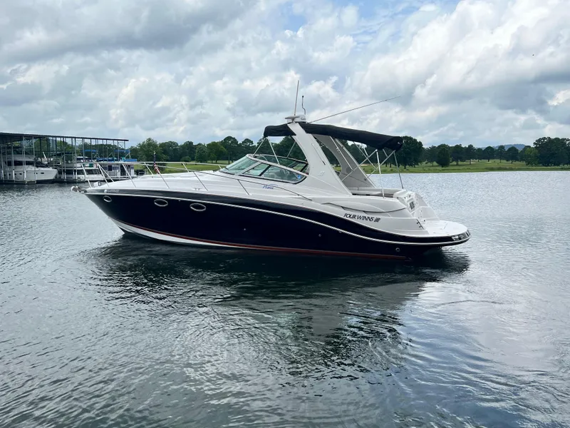 The Image of 2007 Four Winns 358 Vista boat on a calm lake under cloudy skies. - 0