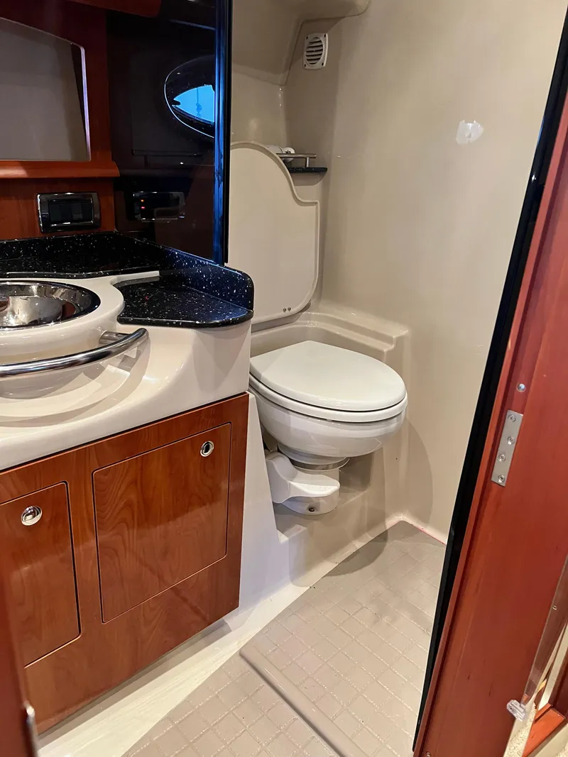 Slide: The Image of 2007 Four Winns 358 Vista boat bathroom with sink, toilet, and wooden cabinetry. - 21