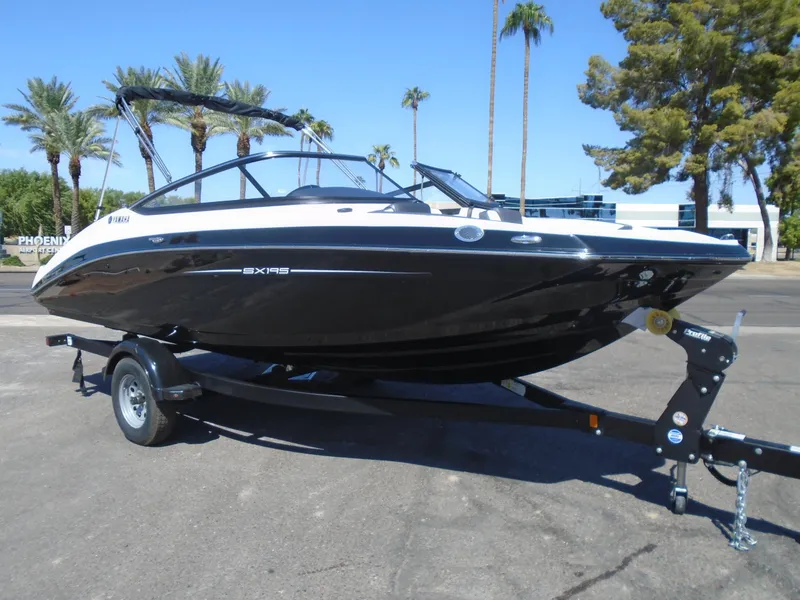 The Image of 2024 Yamaha Boats SX195 on trailer, parked outdoors with palm trees in background. - 1