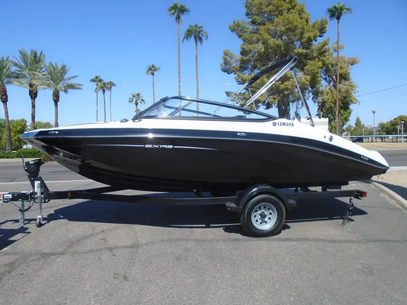 Slide: The Image of 2024 Yamaha SX195 boat on trailer, parked outdoors with palm trees in background. - 4