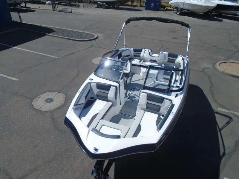 Slide: The Image of 2024 Yamaha Boats SX195, sleek white design, parked on pavement. - 6