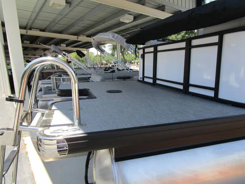 Slide: The Image of 2024 Sweetwater Entertainment SW 2286 MT pontoon boat under a covered dock. - 10