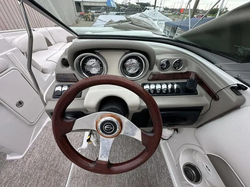 Slide: The Image of 2012 Crownline E1 boat dashboard with wooden steering wheel and instrument panel. - 16