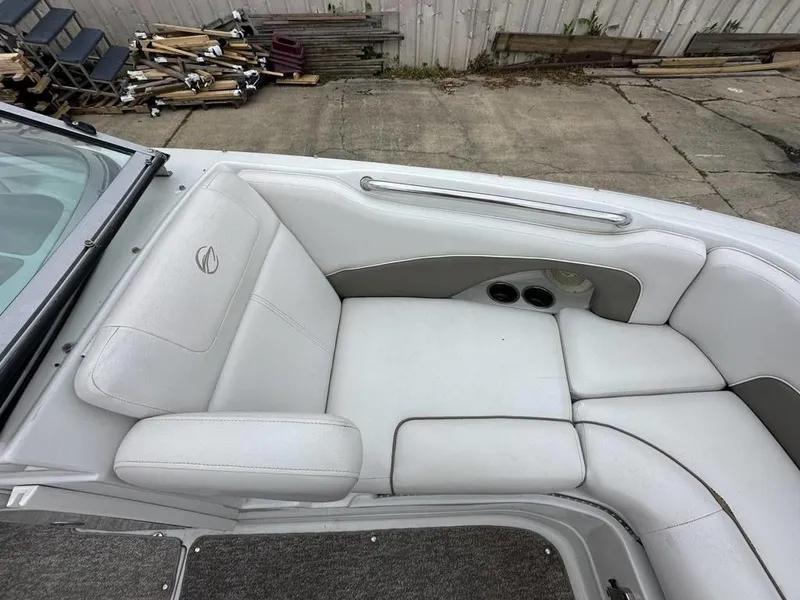 Slide: The Image of 2012 Crownline E1 boat interior with white cushioned seating and cup holders. - 8