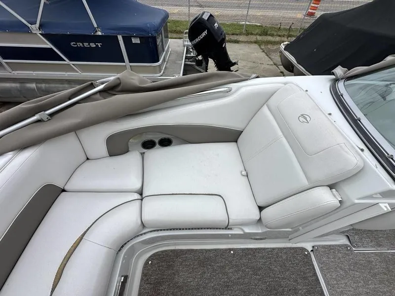 Slide: The Image of 2012 Crownline E1 boat interior with white cushioned seating and cup holders. - 9