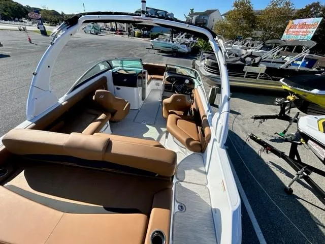 Slide: The Image of 2024 Four Winns HD3 OB boat interior with brown seating, docked at a marina. - 17