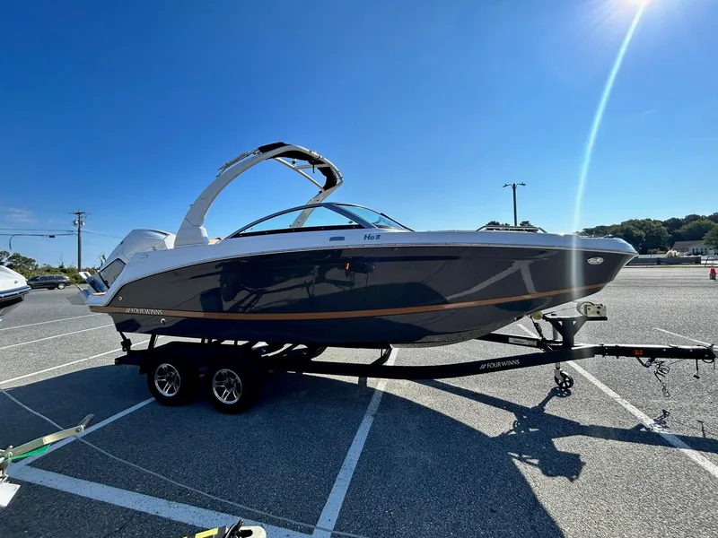 Slide: The Image of 2024 Four Winns HD3 OB boat on a trailer in a parking lot. - 24