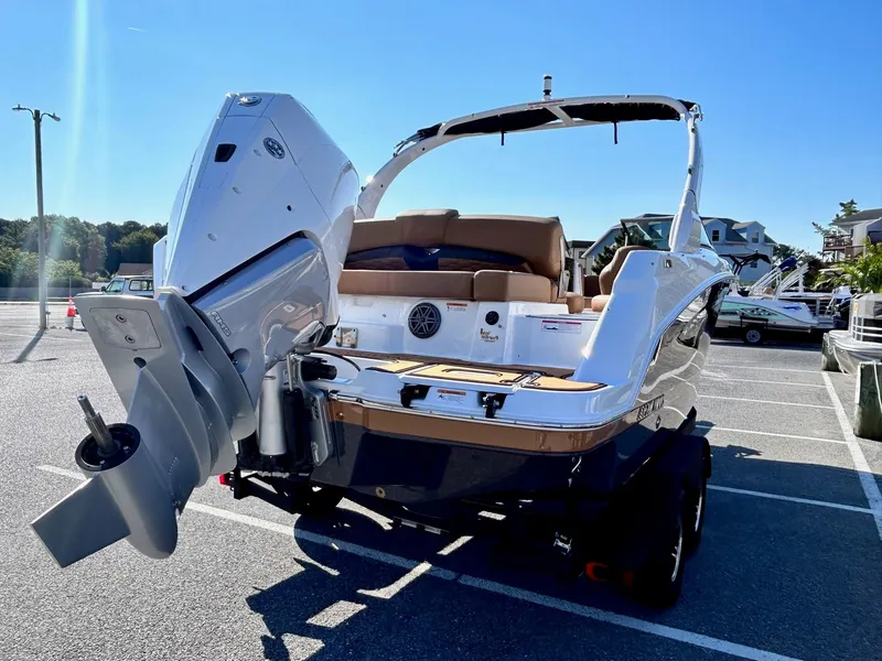 Slide: The Image of 2024 Four Winns HD3 OB boat with outboard motor in a parking lot. - 25