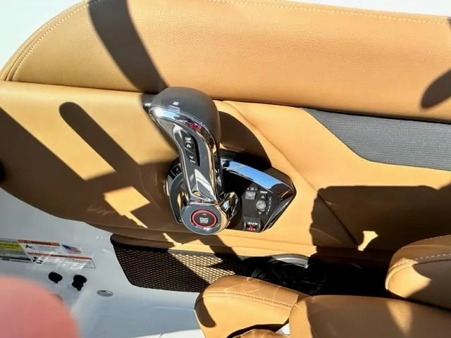 Slide: The Image of 2024 Four Winns HD3 OB boat throttle control and tan leather seating. - 3