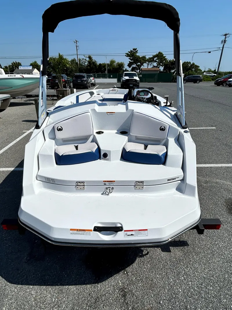 Slide: The Image of 2023 Scarab 165ID boat with dual seating and canopy in a parking lot. - 5