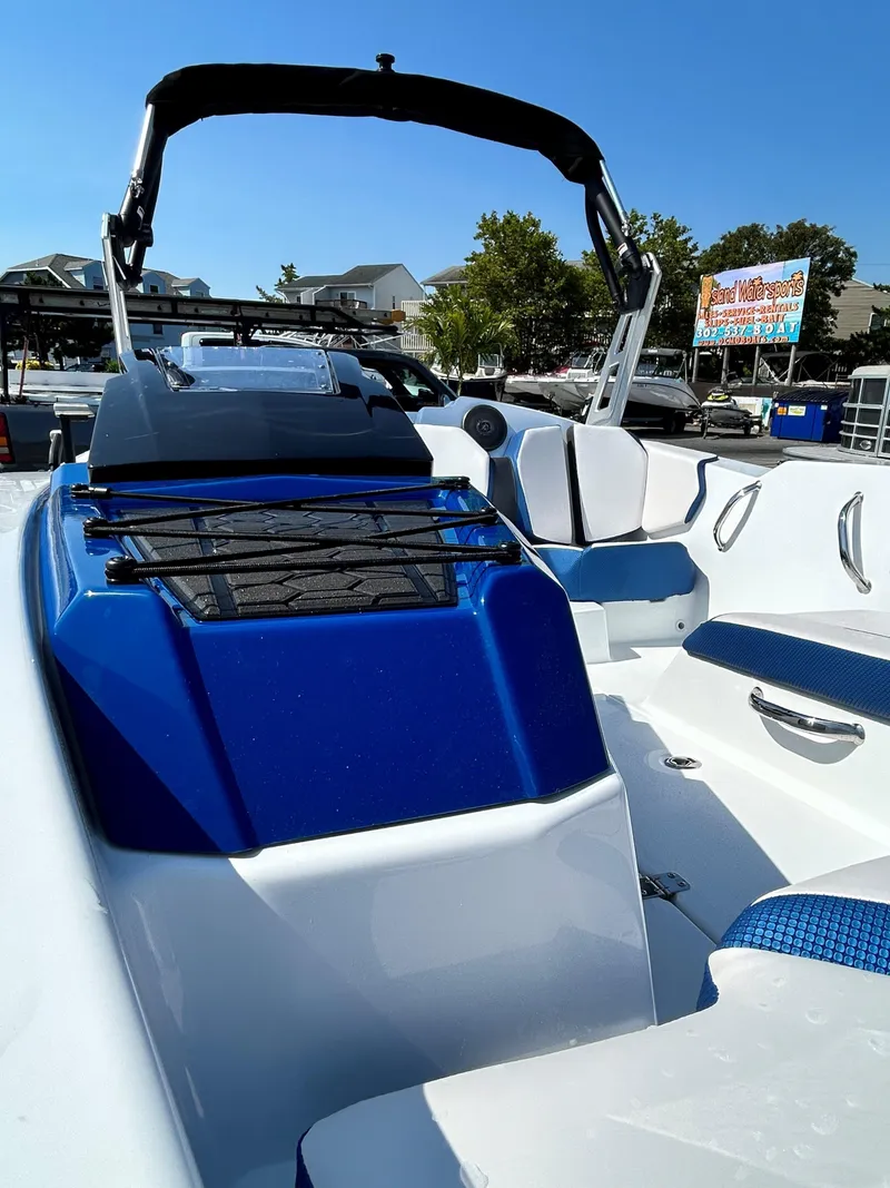 Slide: The Image of 2023 Scarab 165ID boat with blue and white interior, docked under clear skies. - 9