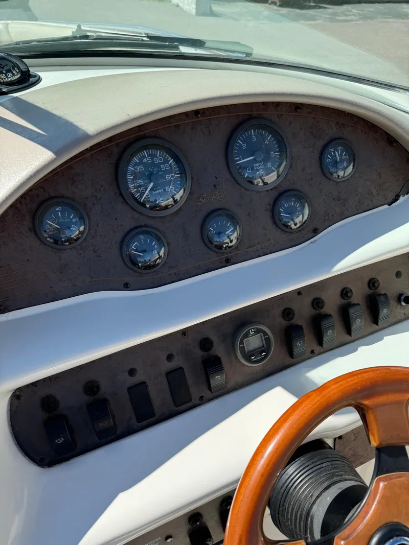 Slide: The Image of Dashboard of a 1996 Sea Ray 260 Bow Rider boat with gauges and controls. - 12