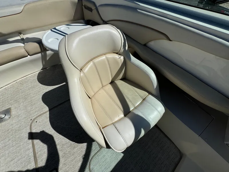 Slide: The Image of 1996 Sea Ray 260 Bow Rider interior with beige seating and cup holders. - 17