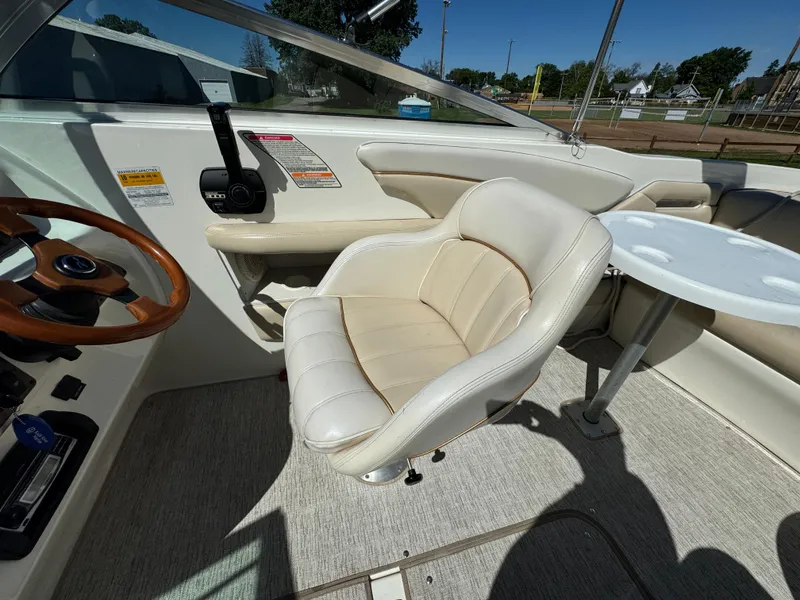 Slide: The Image of 1996 Sea Ray 260 Bow Rider interior with steering wheel and seating area. - 18