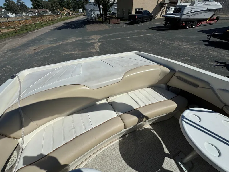 Slide: The Image of 1996 Sea Ray 260 Bow Rider interior with beige seating and small table. - 19
