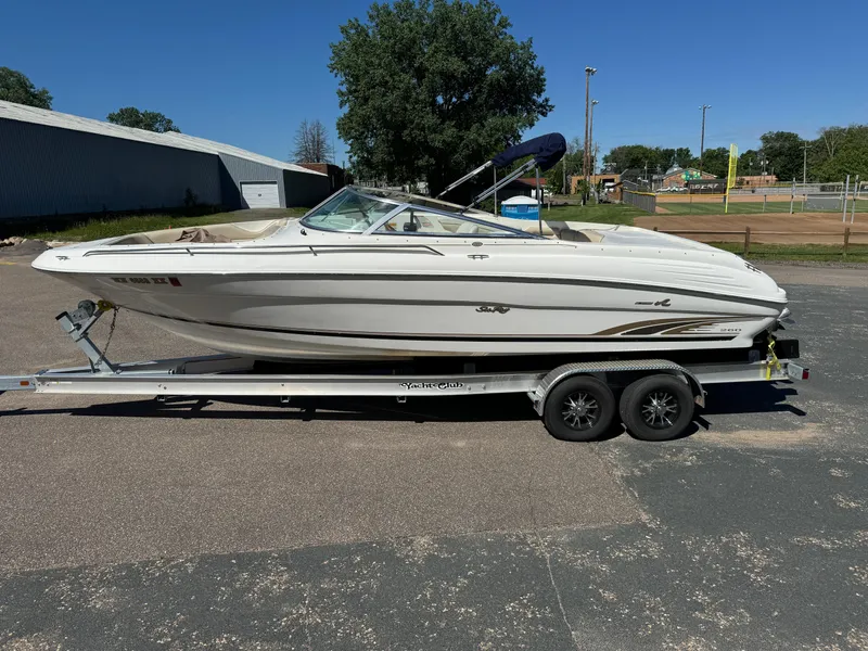 Slide: The Image of 1996 Sea Ray 260 Bow Rider on trailer, parked outdoors under clear blue sky. - 2