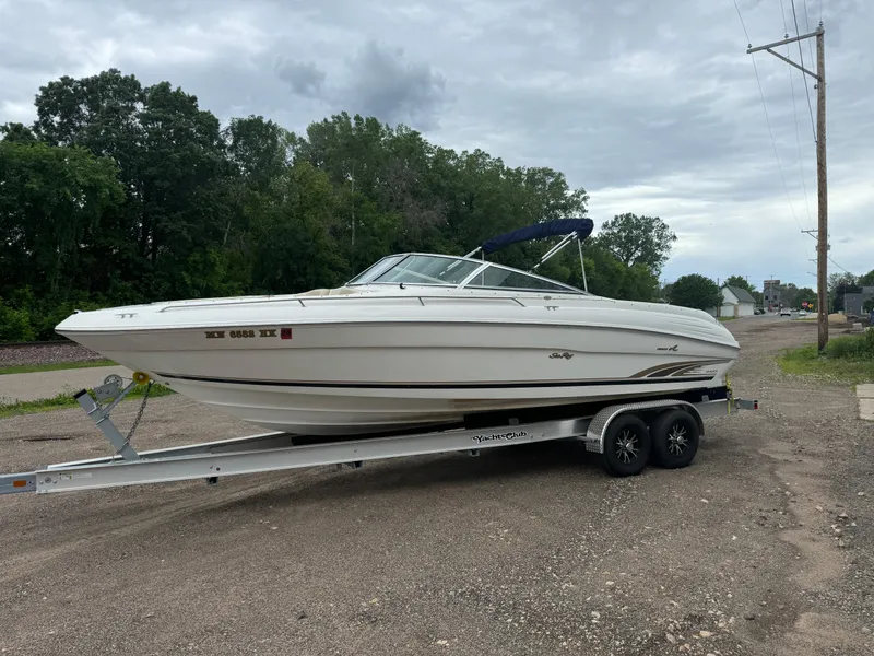 Slide: The Image of 1996 Sea Ray 260 Bow Rider on trailer, parked outdoors with trees in background. - 3