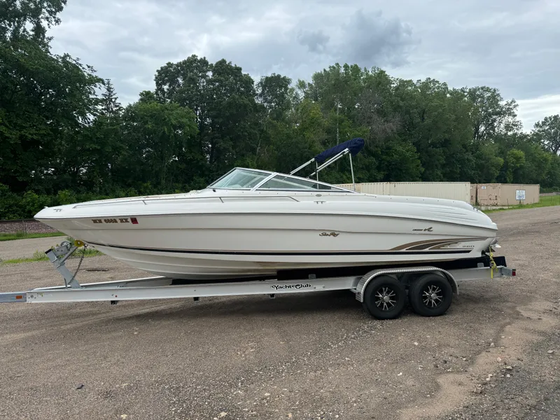 Slide: The Image of 1996 Sea Ray 260 Bow Rider on trailer, parked outdoors with trees in background. - 4