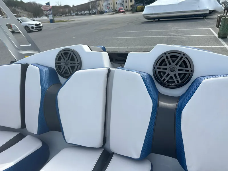 Slide: The Image of 2023 Scarab 165ID boat interior with white and blue seating and built-in speakers. - 15