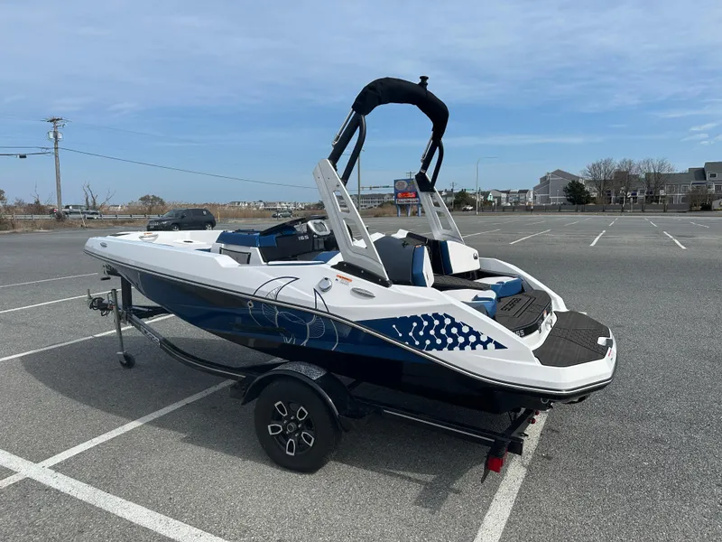 Slide: The Image of 2023 Scarab 165ID boat in parking lot, blue and white design, on trailer. - 6