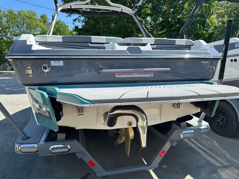 Slide: The Image of 2024 Malibu Wakesetter 21LXR boat rear view with propeller and swim platform. - 2
