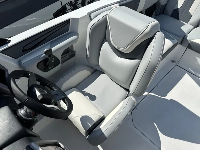 Slide: The Image of 2024 Malibu Wakesetter 21LXR boat interior with gray captain's seat and steering wheel. - 5