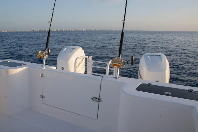Slide: The Image of 2024 Hammer Yachts 35 with fishing rods and dual outboard motors on open sea. - 5