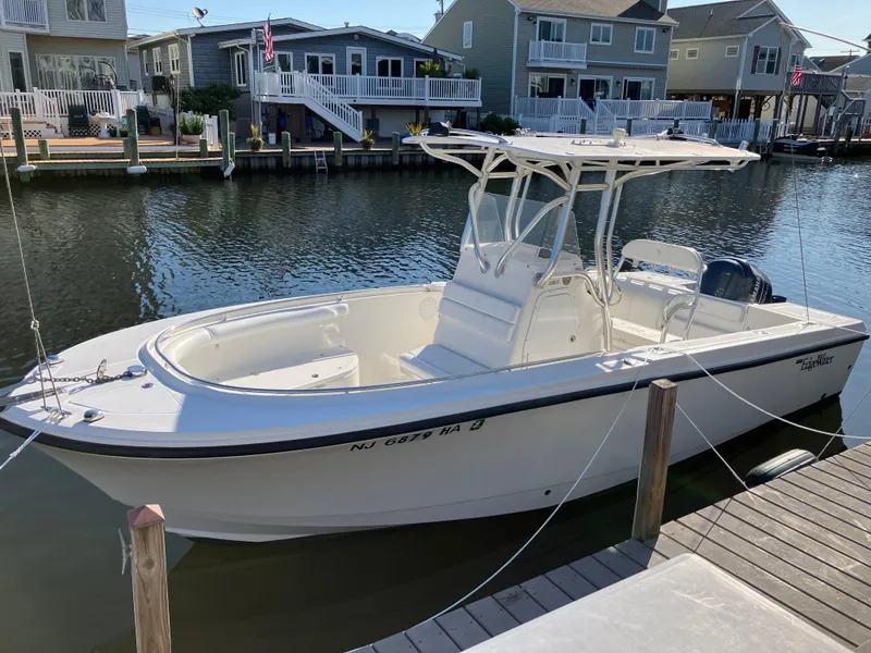 The Image of 2008 Edgewater 228CC boat docked in a residential canal. - 0