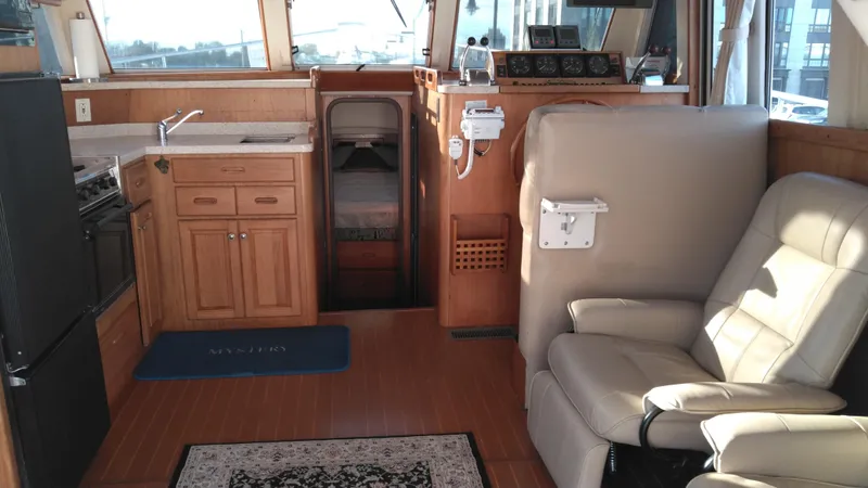 Slide: The Image of 1999 Mainship 350 Trawler interior with kitchen, seating, and sleeping area. - 12