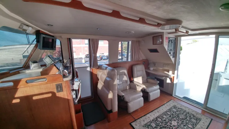 Slide: The Image of Interior of 1999 Mainship 350 Trawler with leather seating and navigation equipment. - 14