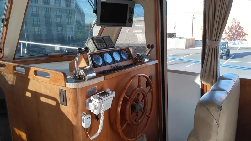 Slide: The Image of 1999 Mainship 350 Trawler helm with wooden steering wheel and navigation instruments. - 18