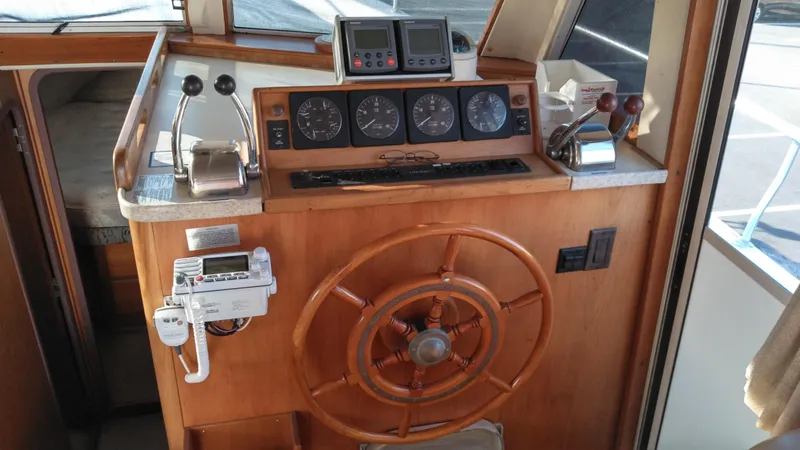 Slide: The Image of 1999 Mainship 350 Trawler helm station with wooden wheel and navigation instruments. - 19