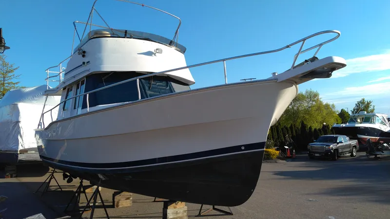 Slide: The Image of 1999 Mainship 350 Trawler boat on stands in a marina. - 2