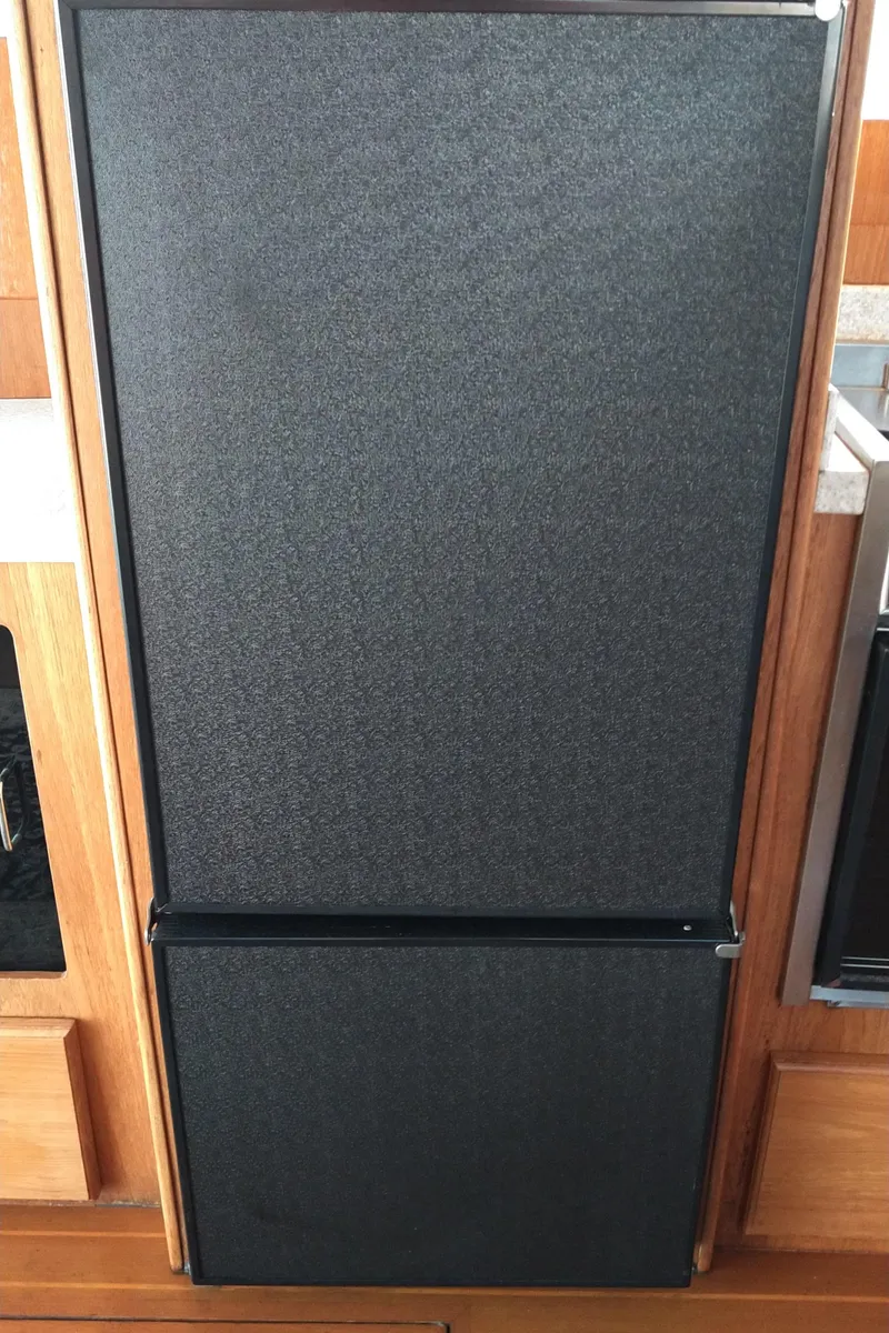 Slide: The Image of Black refrigerator in the galley of a 1999 Mainship 350 Trawler. - 27